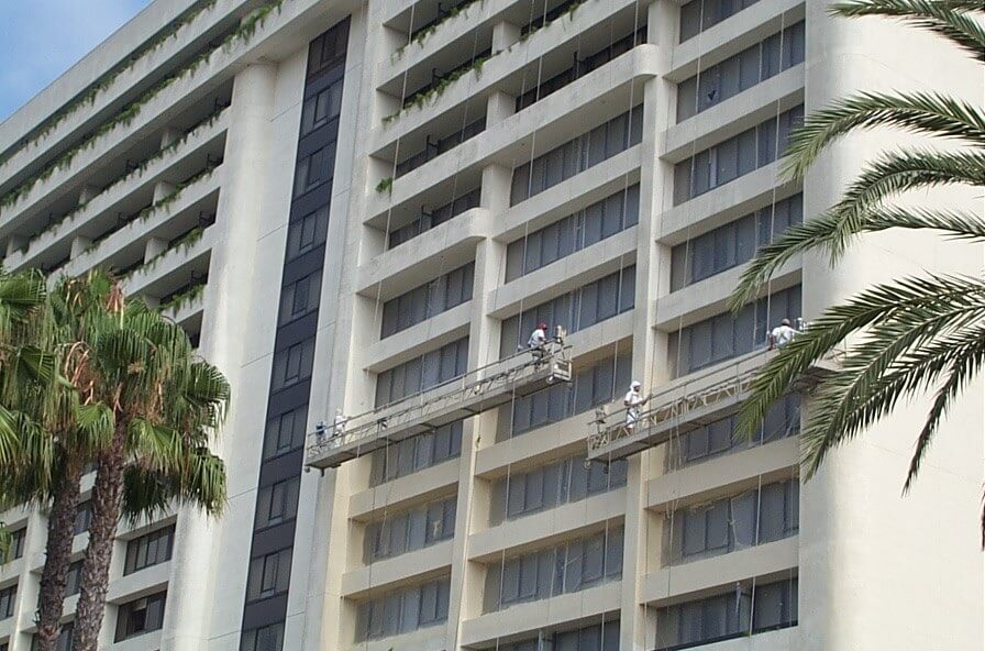painters coating a high rise from stages