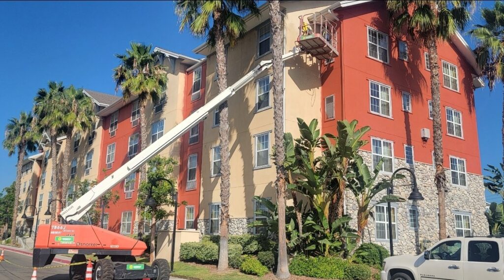 commercial painter on a JLG lift painting a hotel