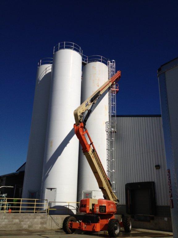 industrial painters working on large chemical silos